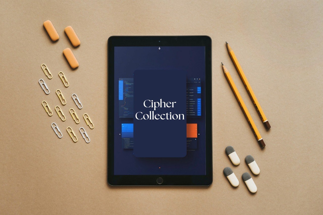 A black tablet centered on a tan surface, displaying the text 'Cipher Collection' on its screen. Surrounding the tablet are orange pill capsules, white and gray capsules, gold and silver paperclips on the left, and two yellow pencils on the right.